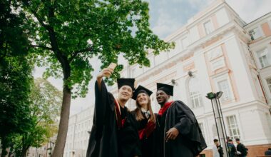 3 women in black academic dress standing near green tree during daytime